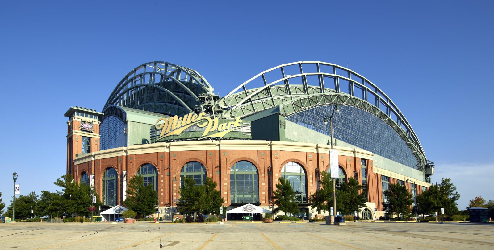 Photograph of Miller Park in Milwaukee, now American Family Field, under a clear blue sky in 2016, with its arched roof trusses and brick facade